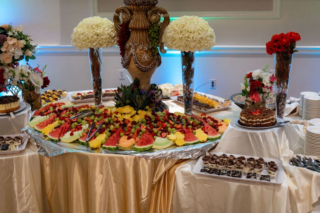 Fresh fruit display and dessert buffet with white floral arrangements
